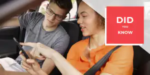Passenger showing a mobile phone to a driver