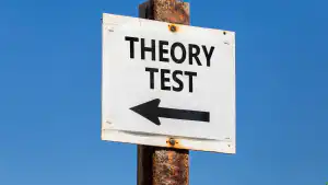 Road sign pointing towards a theory test